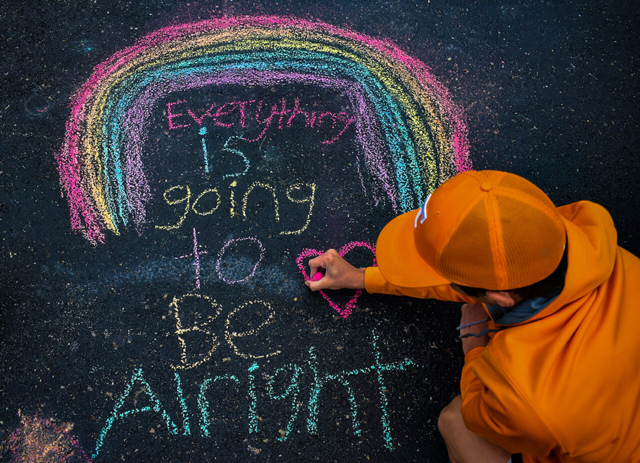 Rian Scott Fann chalks an inspiring messages on the driveway of his home in Dunlap, Tennessee.