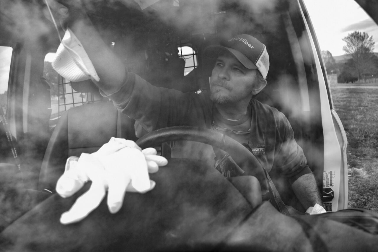 Listed as an essential employee by the government, Brian Fann hangs up his medical mask on his work van's rearview mirror after a long day.