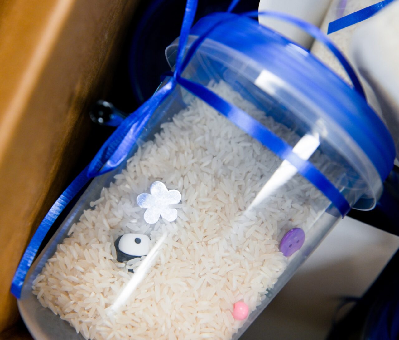 An "I Spy" jar is filled with trinkets and other surprises that are buried in rice.