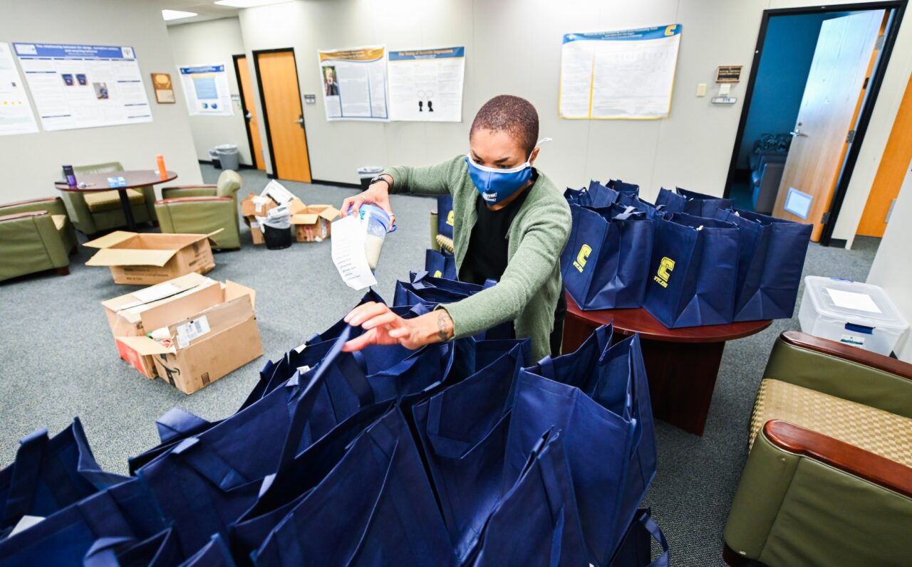 Tomorrow Arnold, associate professor of psychology, loads a bag with items for the residents of Summit View Senior Community.