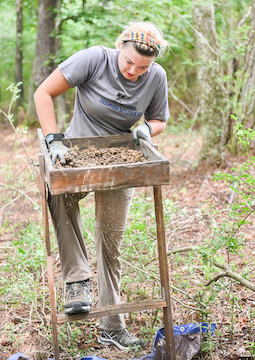 Each student is given a sifter which has a screen bottom that's filled with dirt and shaken back and forth to expose any archaeological artifacts that may be present.