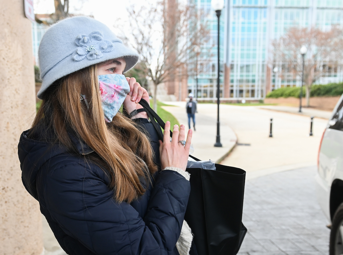 Squoia Holmes, wearing red, and Laney Wood hand out bags full of snacks and necessities Thursday, Dec. 17, 2020 at the University Center.