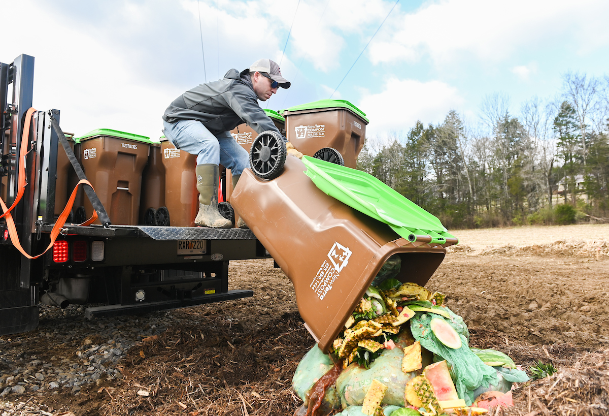 Normand Lavoie dumps a fresh load of food scraps from a bin.