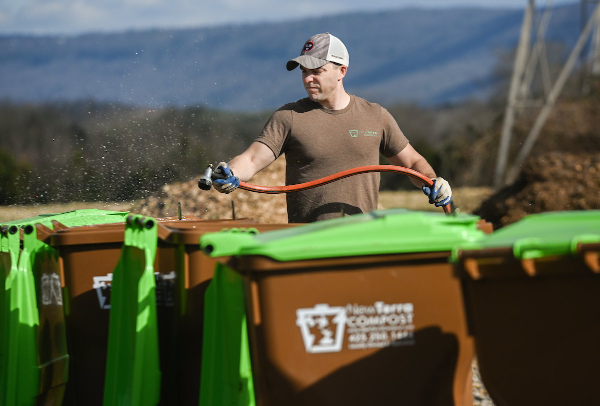 Normand Lavoie cleans out the 65-gallon bins that commercial customers use for food scraps.