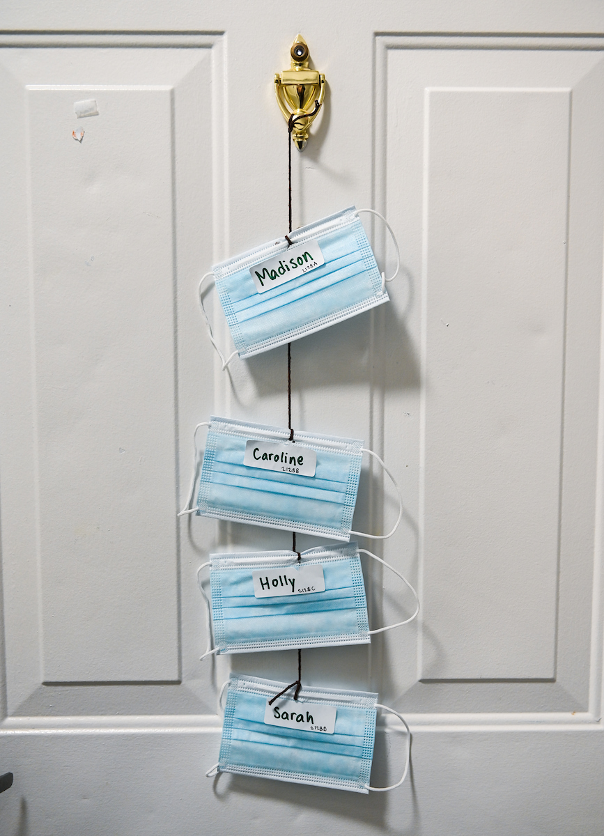 Names and masks hang on doors inside Decosimo Apartments.