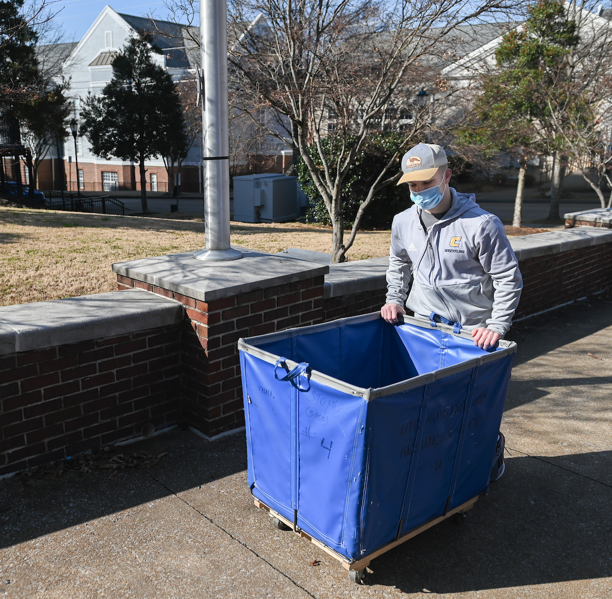 Matthew Williams pushes a tub full of his belongings into UC Foundation Apartments.