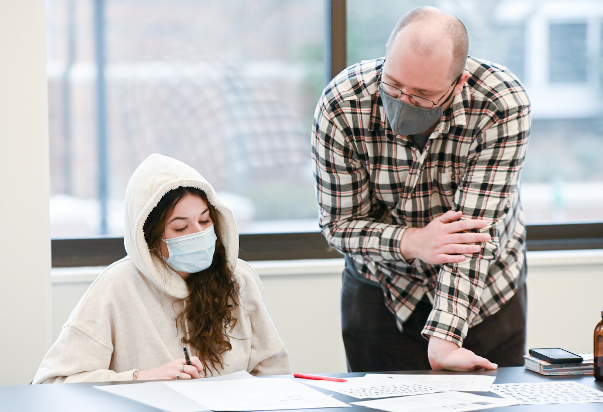 Professor Derek Witucki helps a student in his Typography class.