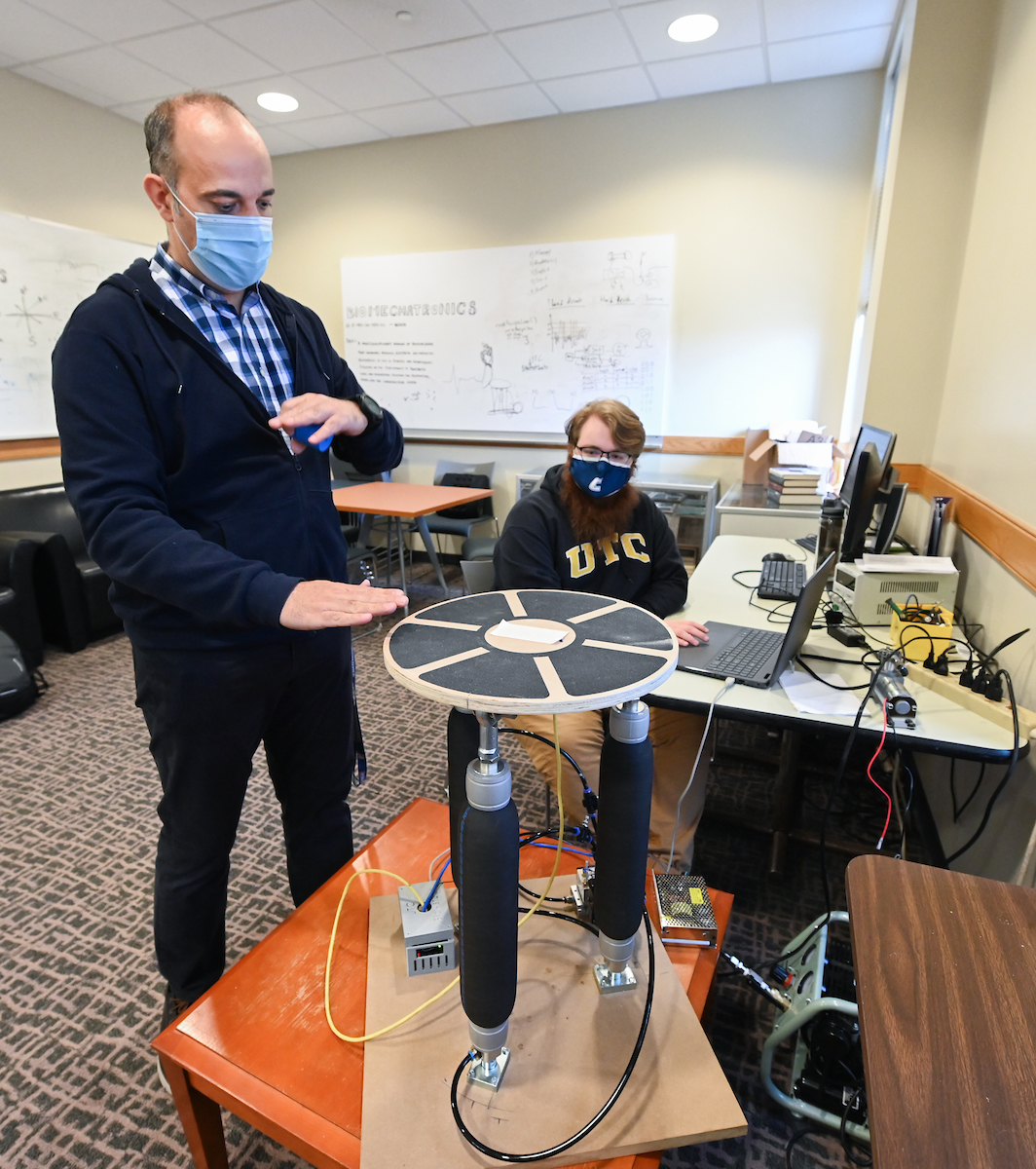 Erkan Kaplanoglu, standing, and Mickael Young, seated, demonstrate an EMG controlled balance board. Designed with Erlanger Orthopedic Surgeon Dr. Jeremy Bruce, Physical Therapy Assistant Professor Max Jordon and Engineering Management and Technology Department Head Ahad Nasab. The balance board can help evaluate and treat motor control deficiencies in individuals with chronic low back pain, Cerebral Palsy and other other development disorders.