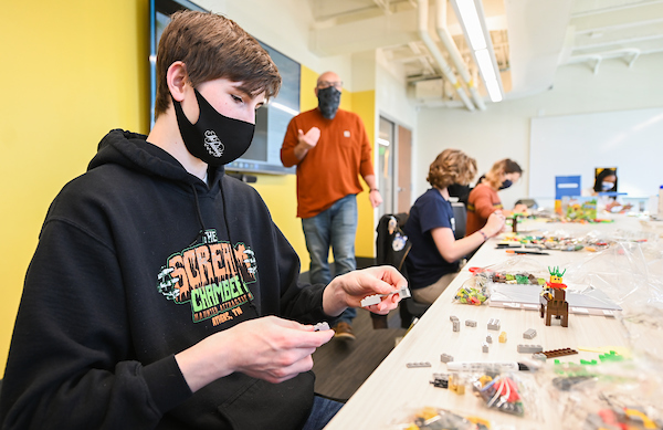 Jaden Partain starts choosing which building blocks he will sue. Professor Owen Foster is in the orange shirt in the background.