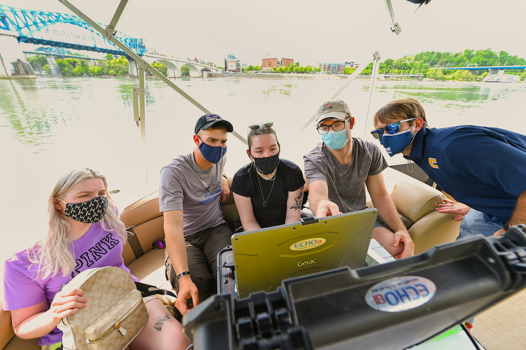 Students, from left, Alexis Boydston, Sam Fuller, India Toth and Gavin Page and Assistant Professor Morgan Smith watch a sonar screen that shows ship wreckage on the bottom of the Tennessee River.
