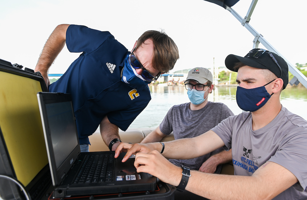 Assistant Professor Morgan Smith leans in with Gavin Page, center, and Sam Fuller.