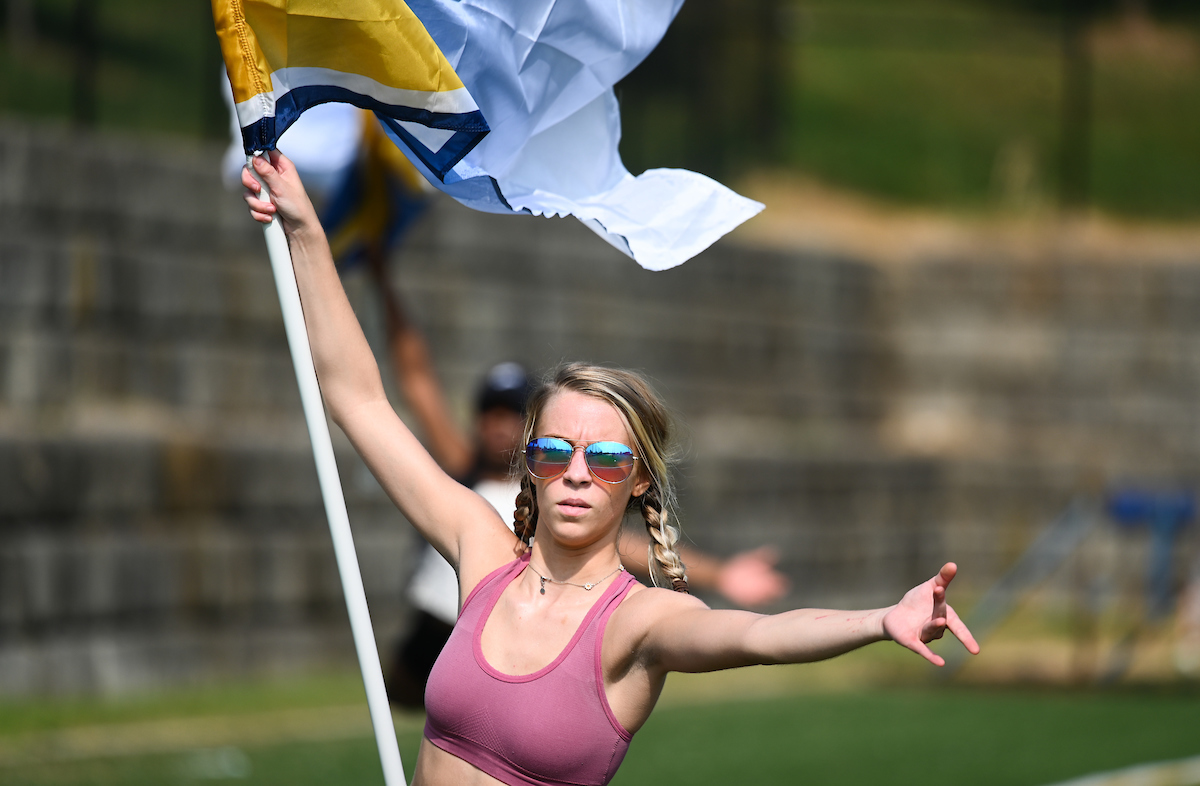 Marching Mocs member performs flag routine outdoors.