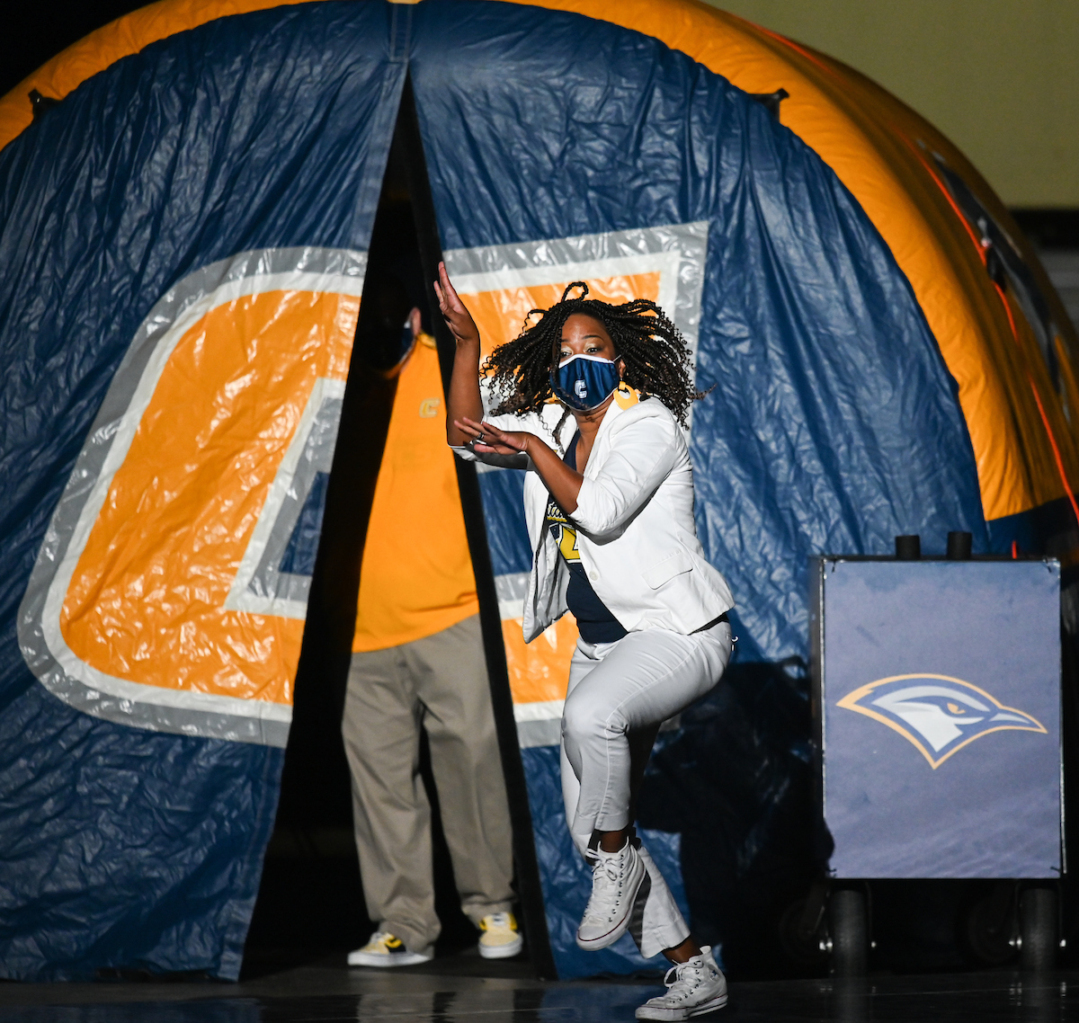 Woman dancing out of the tunnel with a "Power C" on it.