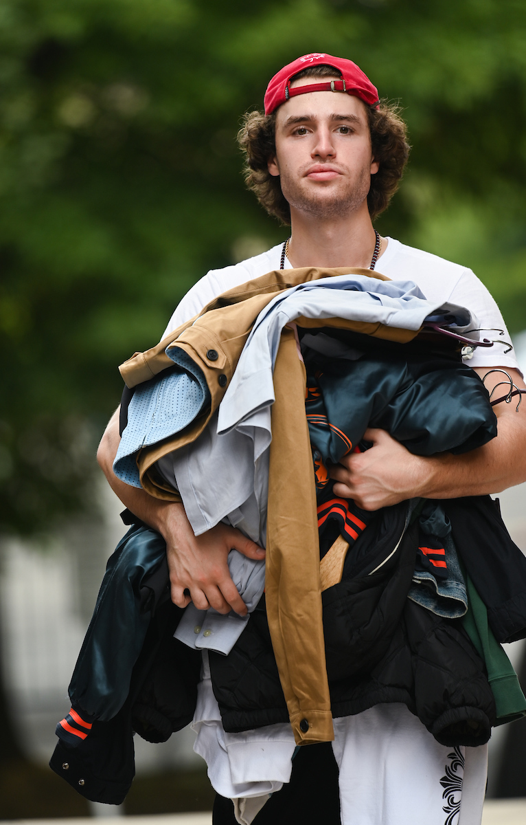 Student carries stack of clothes during Operation Move-In.