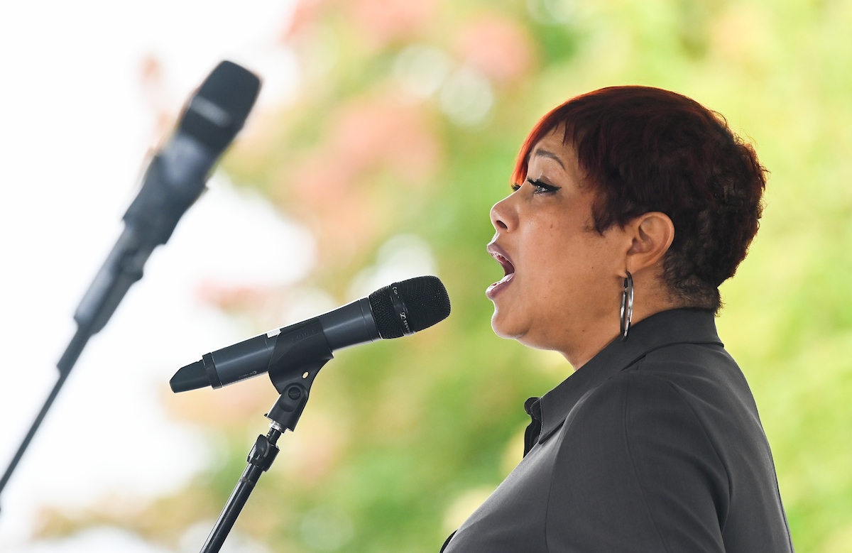 Jacquie Ramsey is singing into the microphone.