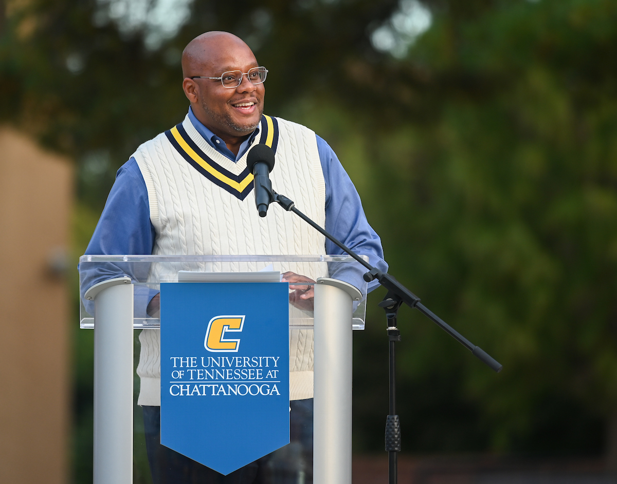 Yancy Freeman speaking at a podium outside.