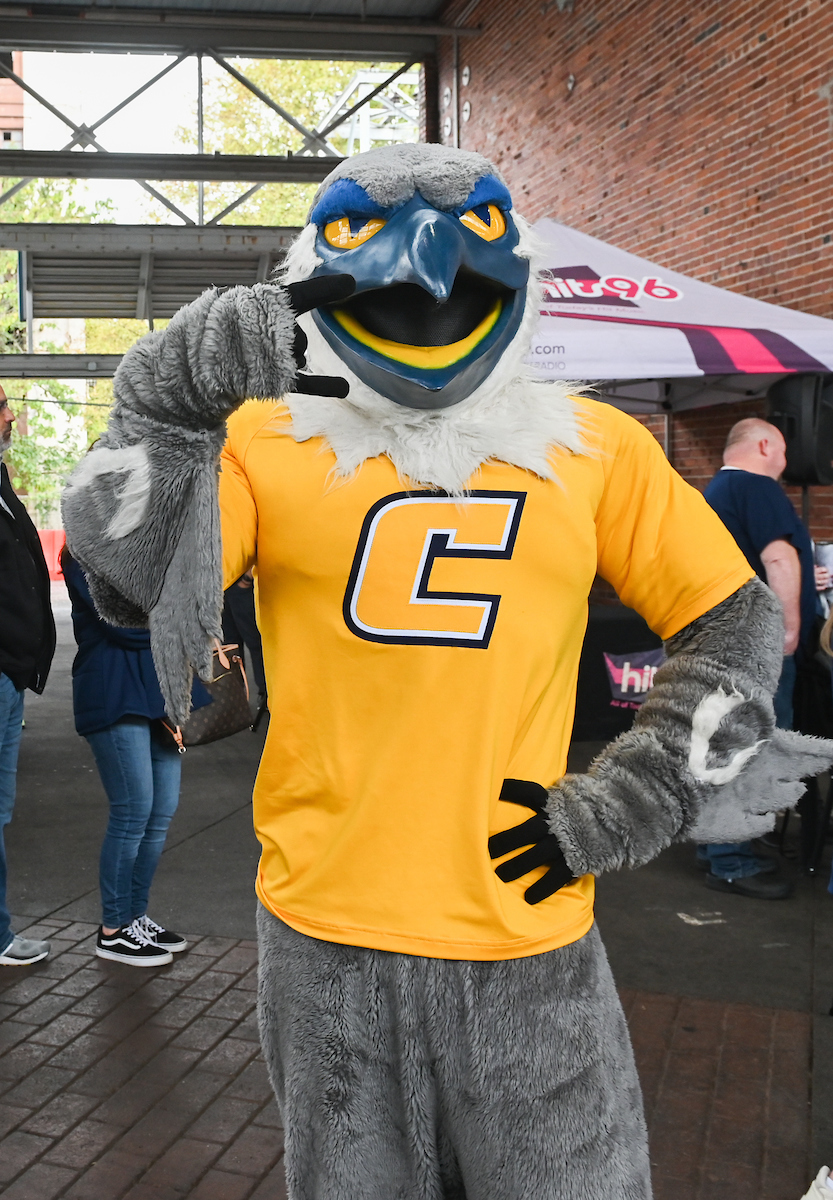 Scrappy poses cheerfully holding up the "Power C".