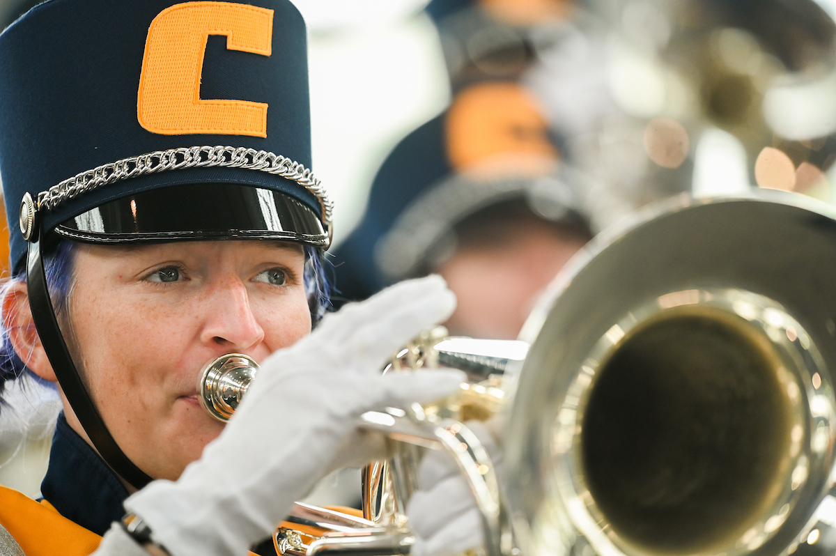 A marching mocs member plays a brass instrument.