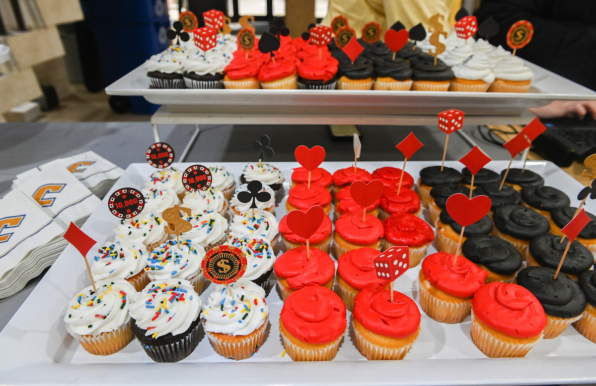 Colorful gaming-themed cupcakes are displayed on trays.