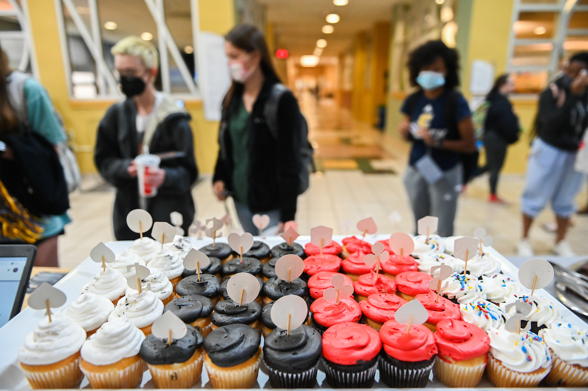 Colorful gaming-themed cupcakes are displayed on trays.