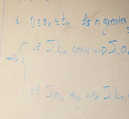 Handwritten mathematical notation in blue ink on a whiteboard.