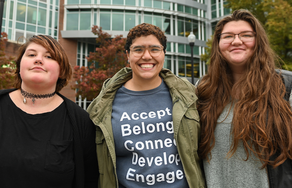 Tobias Headrick, Katie Crutchfield and Shyanne Machotka stand in front of the library.