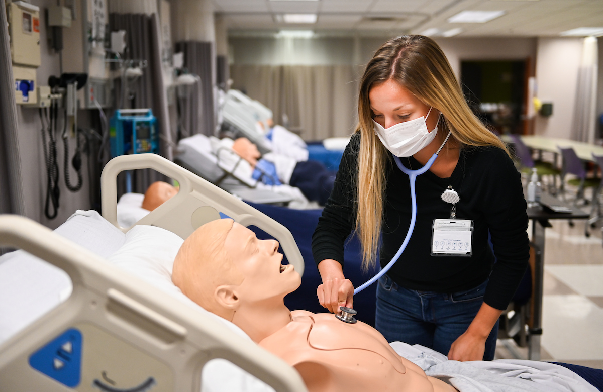 UTC student Megan Kaufman, uses a stethoscope on a medical training mannequin in a lab inside the Metro building.