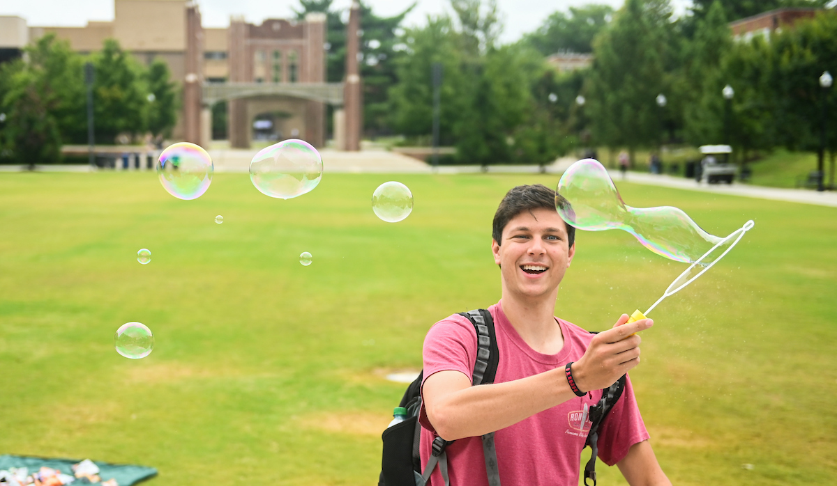 A student blows bubbles on Chamberlain field on Monday, Aug. 16, the first day of fall classes.