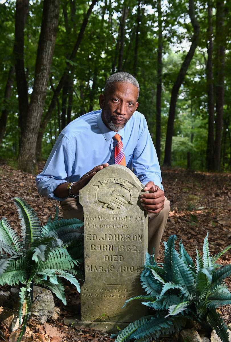 LaFrederick Thirkill kneels beside the grave of Ed Johnson in Pleasant Gardens Cemetery. Thirkill was instrumental in the organization of a memorial for Ed Johnson at the Walnut Street Bridge, where Johnson was lynched in 1906.