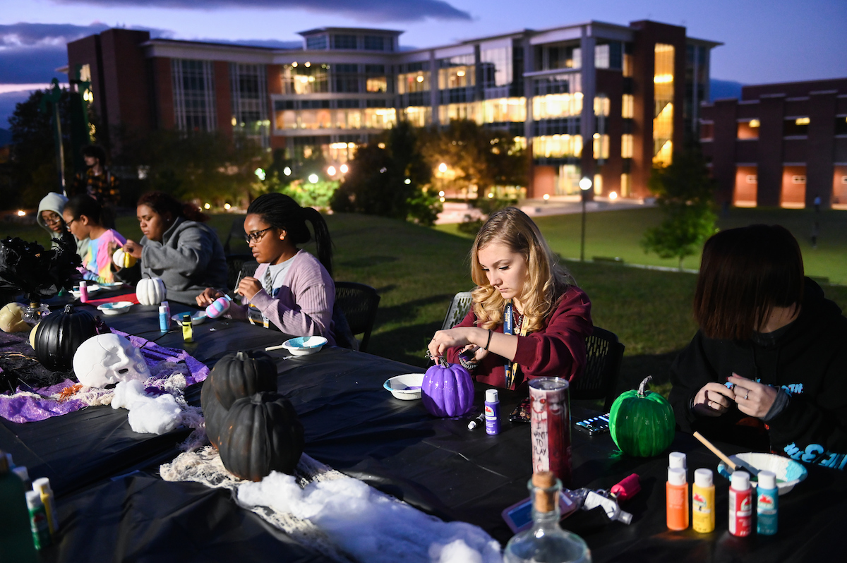 Students paint pumpkins on Oak Street during an event sponsored by the Center for Student Success.