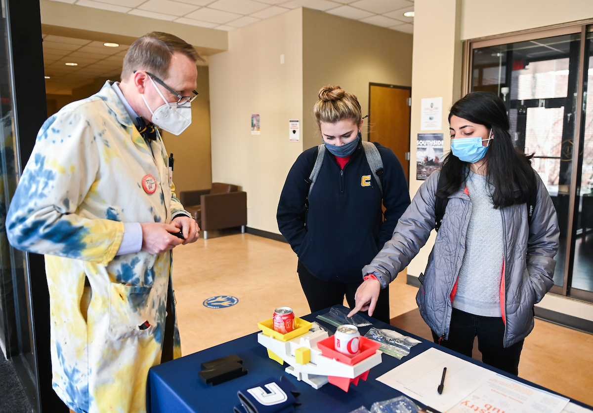 Chemistry Professor Keenan Dungey helps students participate in the Science of Sugar and Snow during Winter Welcome.