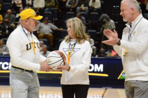 The Allens were recognized for their philanthropy by Vice Chancellor and Director of Athletics Mark Wharton, right, during the UTC/Mercer men’s basketball game on Feb. 5. Photo courtesy Laura O’Dell/UTC Athletics.