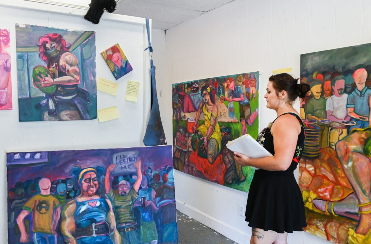 Senior art student Ren Collins displays work during the Painting and Drawing Open Studios event Thursday, April 29, 2022 in the carriage house art studios.