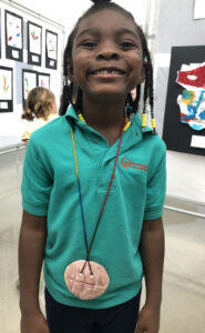 Kindergartener Brianna Johnson proudly displays her medallion.