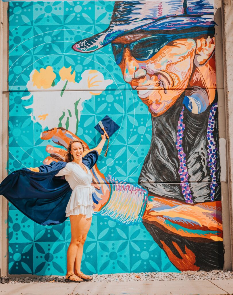 Shortly after participating in UTC commencement ceremonies on May 7, Madison Myers—with family and friends watching—completed “Sandy The Flower Man.” Photo by Chris Campbell.