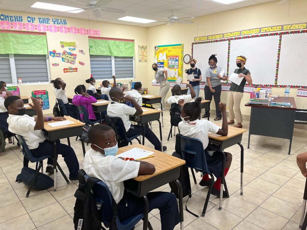 Recent UTC Honors College graduate Sydney Ellis, left, and MPH students Jillian Saraney, Taylor Teasley and Taylor Yates lead a San Salvador Island fifth grade class discussion about how eating nutritious foods makes you strong. Photo by Emma Sampson.