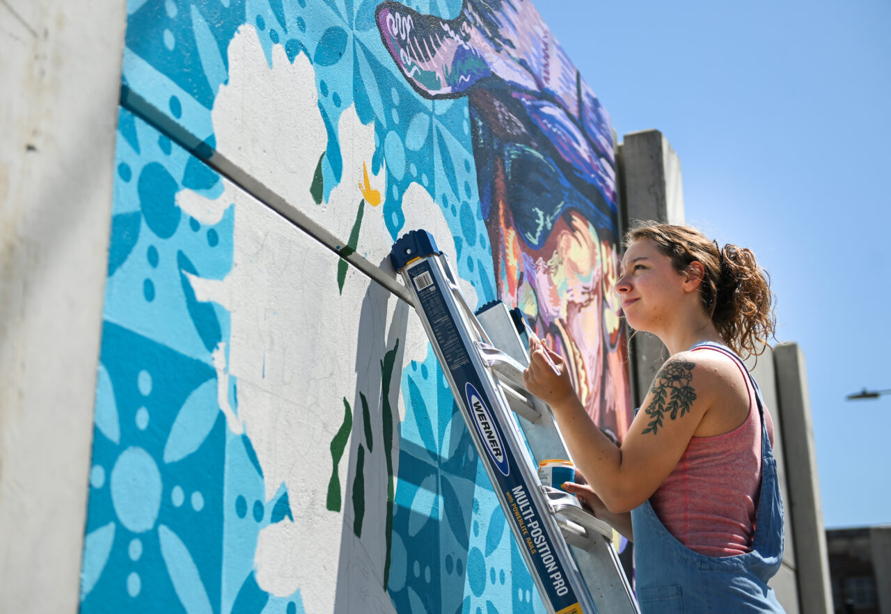 Madison Myers works Wednesday, April 27, 2022 on her mural at the EPB building near MLK Blvd.