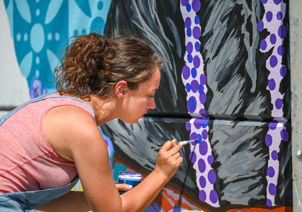 Madison Myers works Wednesday, April 27, 2022 on her mural at the EPB building near MLK Blvd.