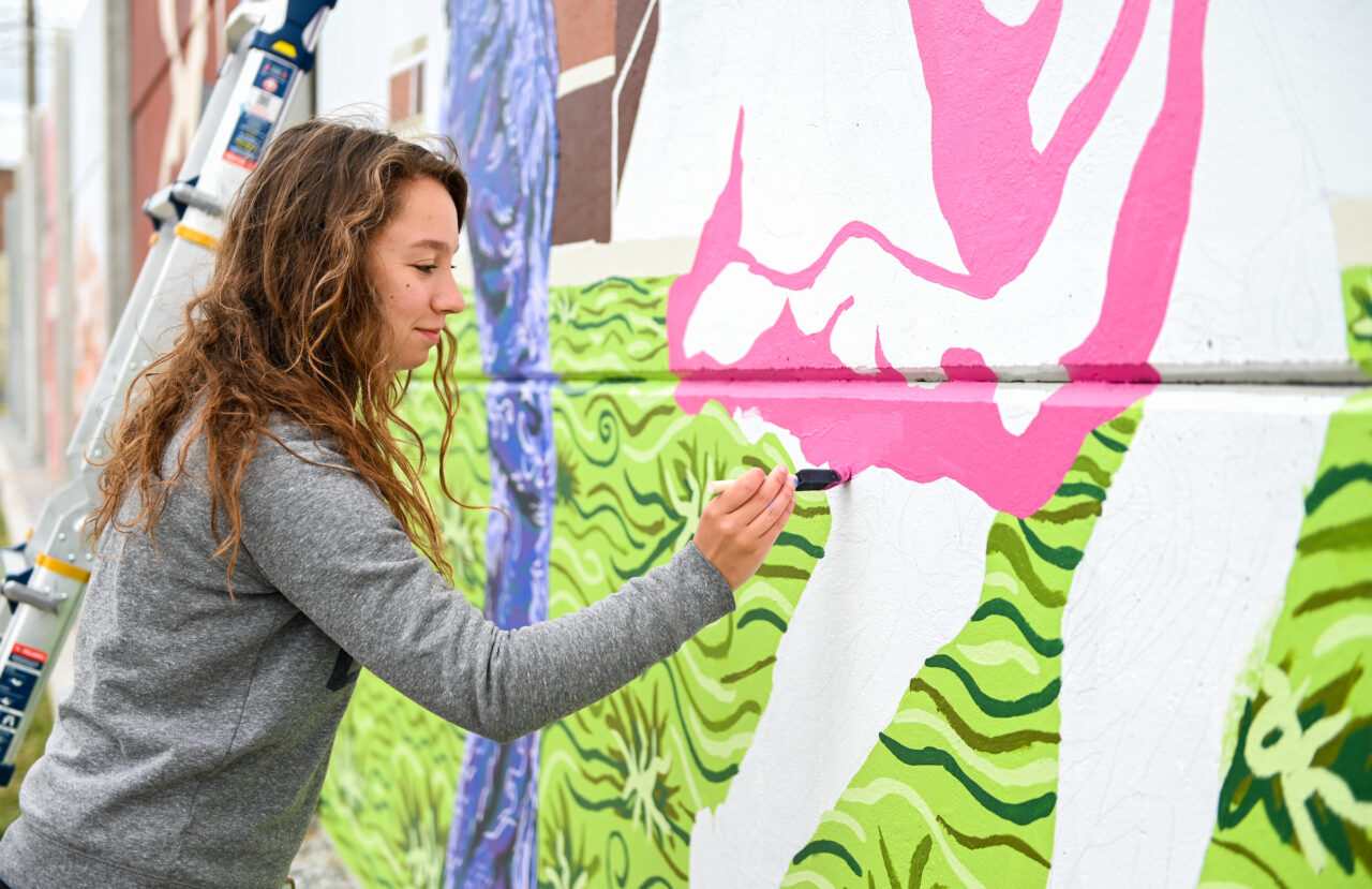Madison Myers works on her mural Wednesday, April 21, 2021 on 10th Street.
