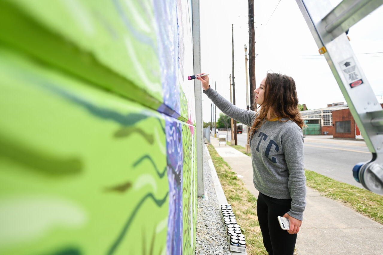 Madison Myers works on her mural Wednesday, April 21, 2021 on 10th Street.