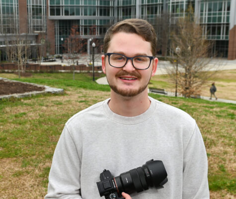 Jerrod Niles, camera in hand, standing outside UTC Library