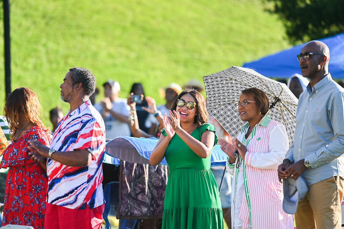 Audience members clap and sing during the Juneteenth celebration on Chamberlain Field.