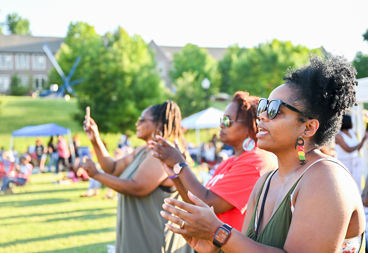 Audience members clap along during the Juneteenth celebration on Chamberlain Field.