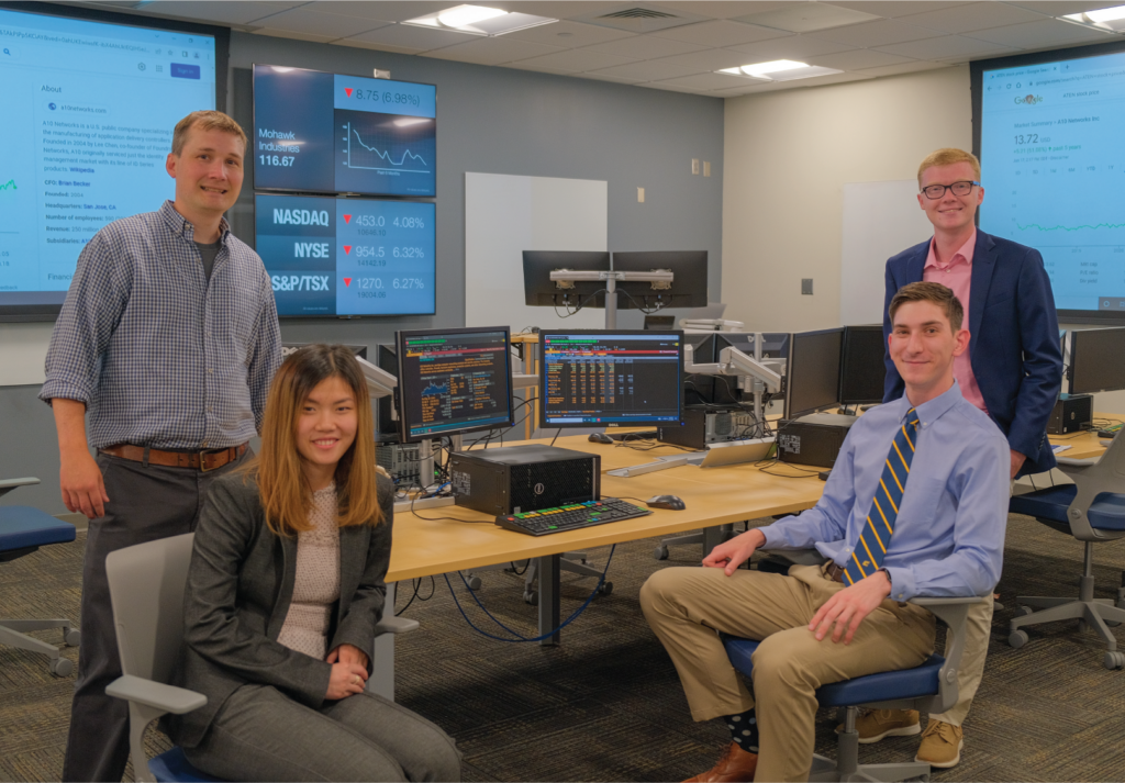 SMILE Fund Director Hunter Holzhauer, left, and the winners of the Channelchek Research Report College Challenge: Kim Hoang Do, Justin Martin and Jackson Howard.