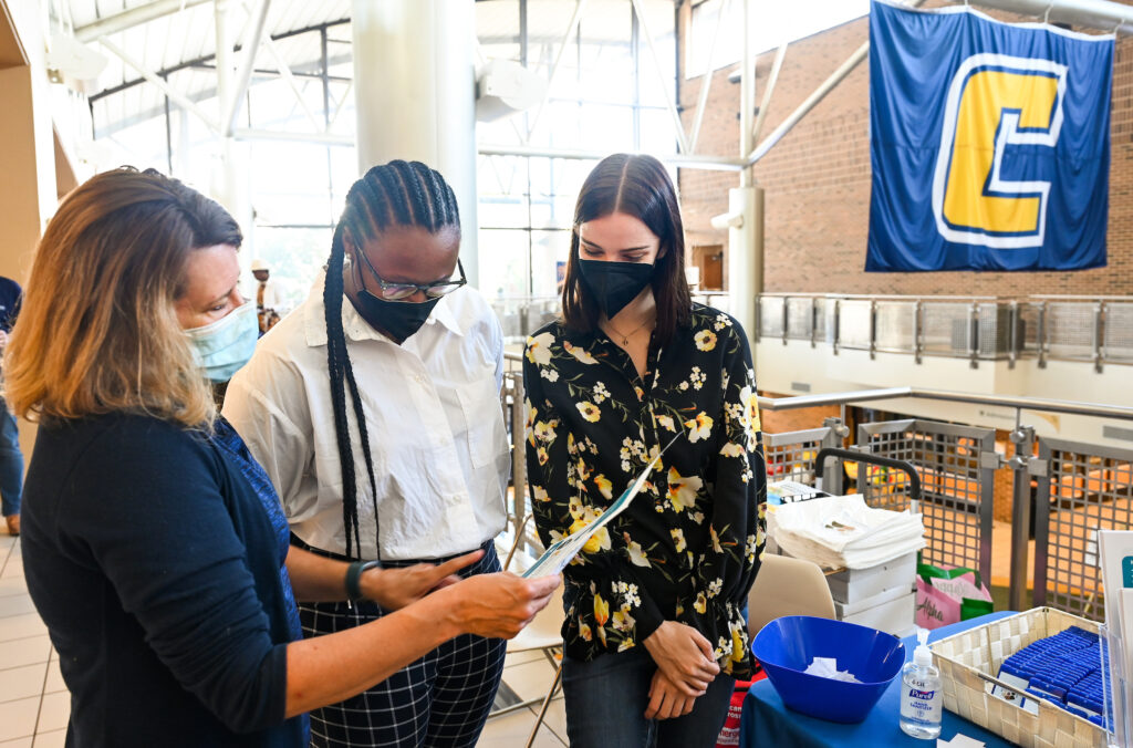 Dawn Ford, left, an assistant professor in the UTC Master of Public Health program, consults with MPH graduate students Taylor Teasley and Jillian Saraney at the 21st annual Hamilton County Minority Health Fair . Photo by Angela Foster.