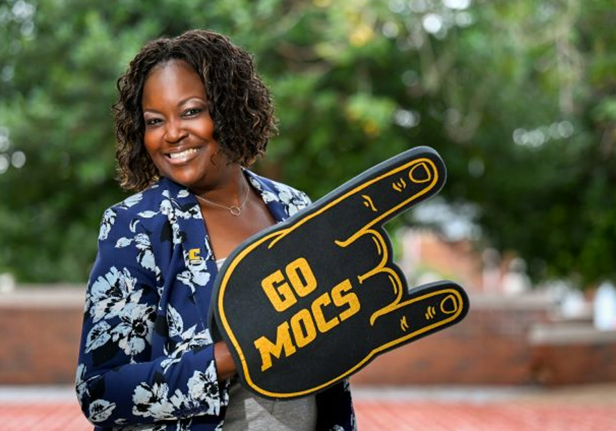 Convocation coordinator Tonya Love, holding a fuzzy GO MOCS hand, is the director of university events for UTC.