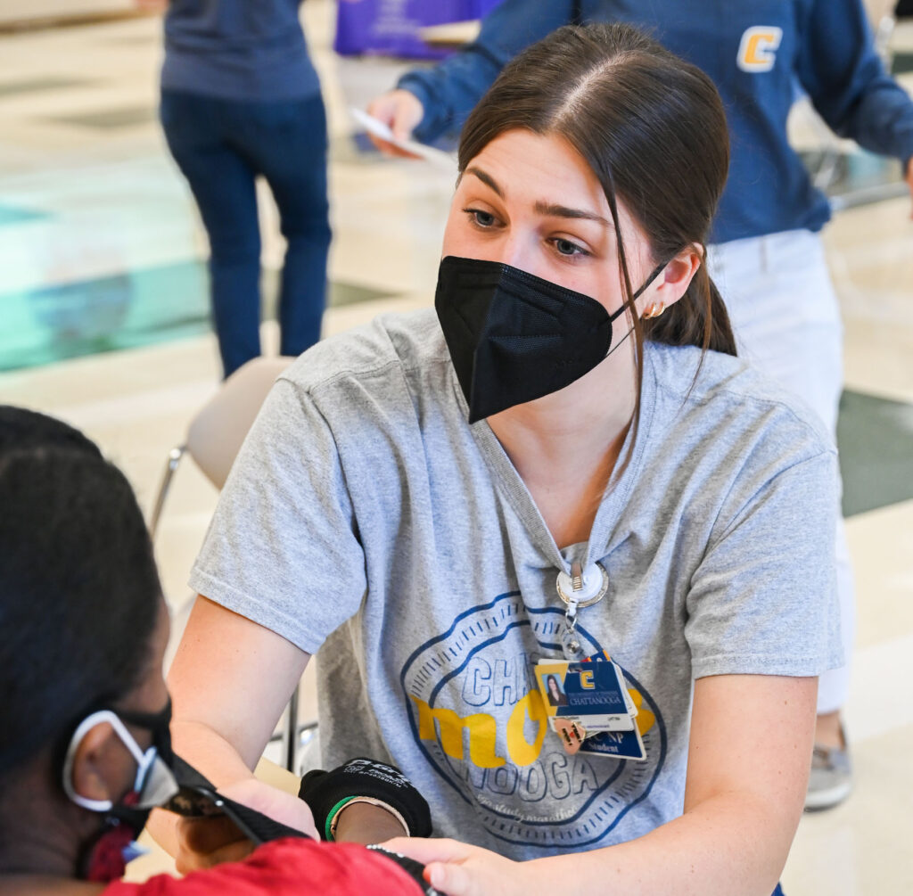 Nikki Goddard, a graduate student in the family nurse practitioner program, talks to a Minority Health Fair attendee.