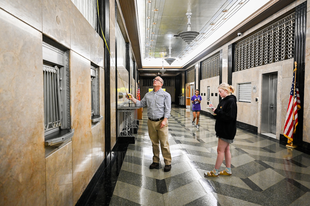 Professor Cullon Hooks points out details inside the Joel W. Solomon Federal Courthouse to students Maddie Shaw.