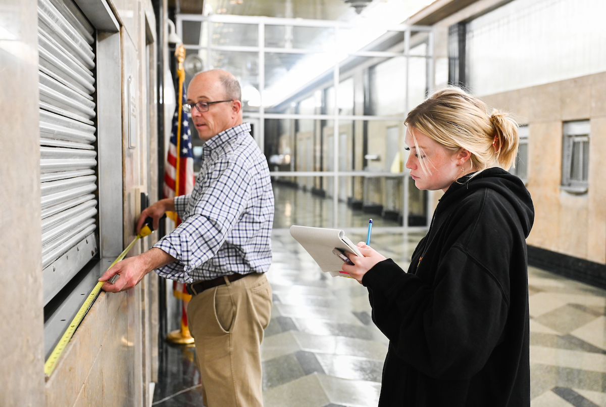 Professor Cullon Hooks helps UTC student Maddie Shaw take measurements inside the Joel W. Solomon Federal Courthouse.