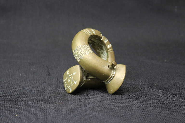 This aluminum manilla shares many features in common with the silver manillas crafted by members of the Tuareg tribe of the Mali-Niger area or with the arm rings worn by the Agadez people, also of the Mali-Niger region.